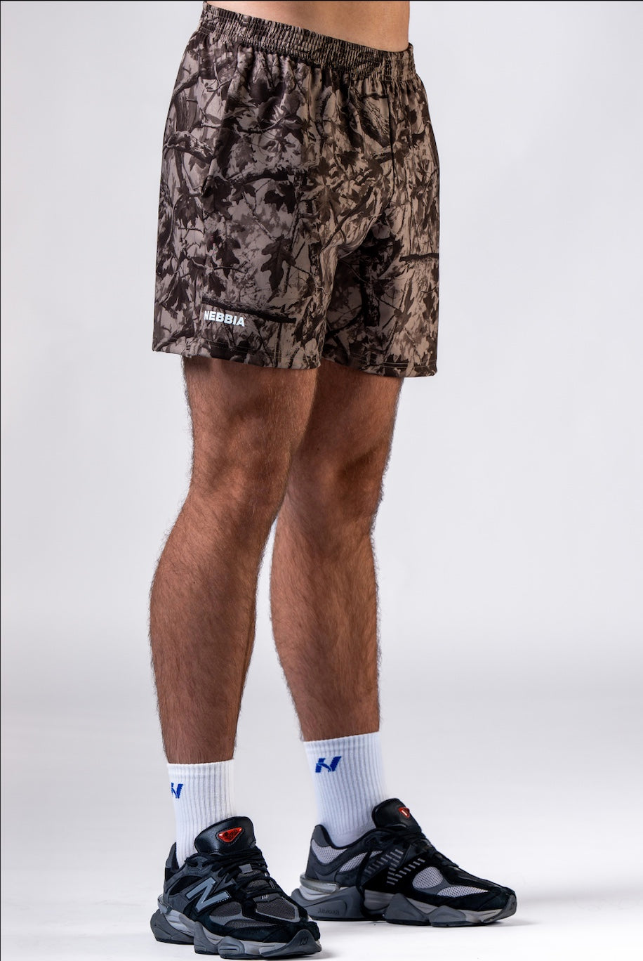 Front view of NEBBIA 902 Power Training Shorts in Black & Light Brown Camo on an athlete.