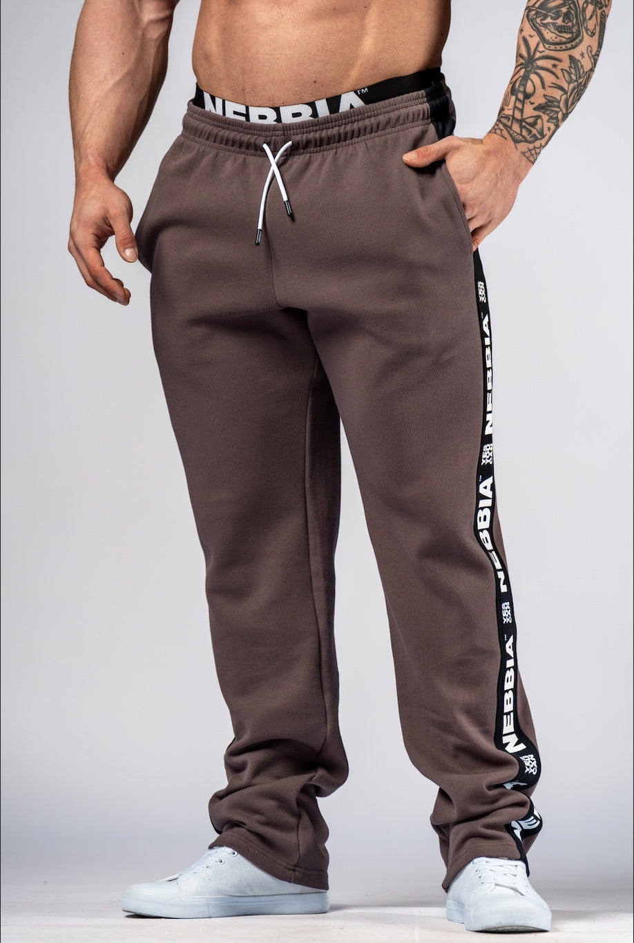 Front view of NEBBIA Hero 296 Training Sweatpants in Black/Brown featuring a tapered athletic fit and branded side-tapes.