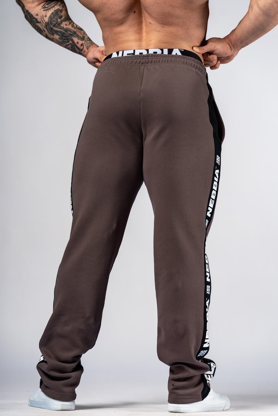 Close-up side view of NEBBIA 296 joggers highlighting the iconic heritage lampas and premium piqué fabric texture.