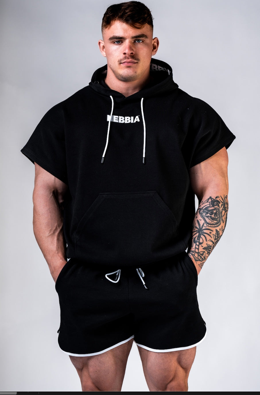 Front view of NEBBIA Hero 297 Training Rag Top in Black-on-Black with a powerful athletic silhouette and chest logo.