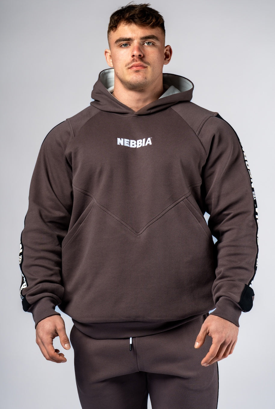 Front view of NEBBIA Hero 300 Training Hoodie in Black/Brown, highlighting the powerful silhouette and chest logo.