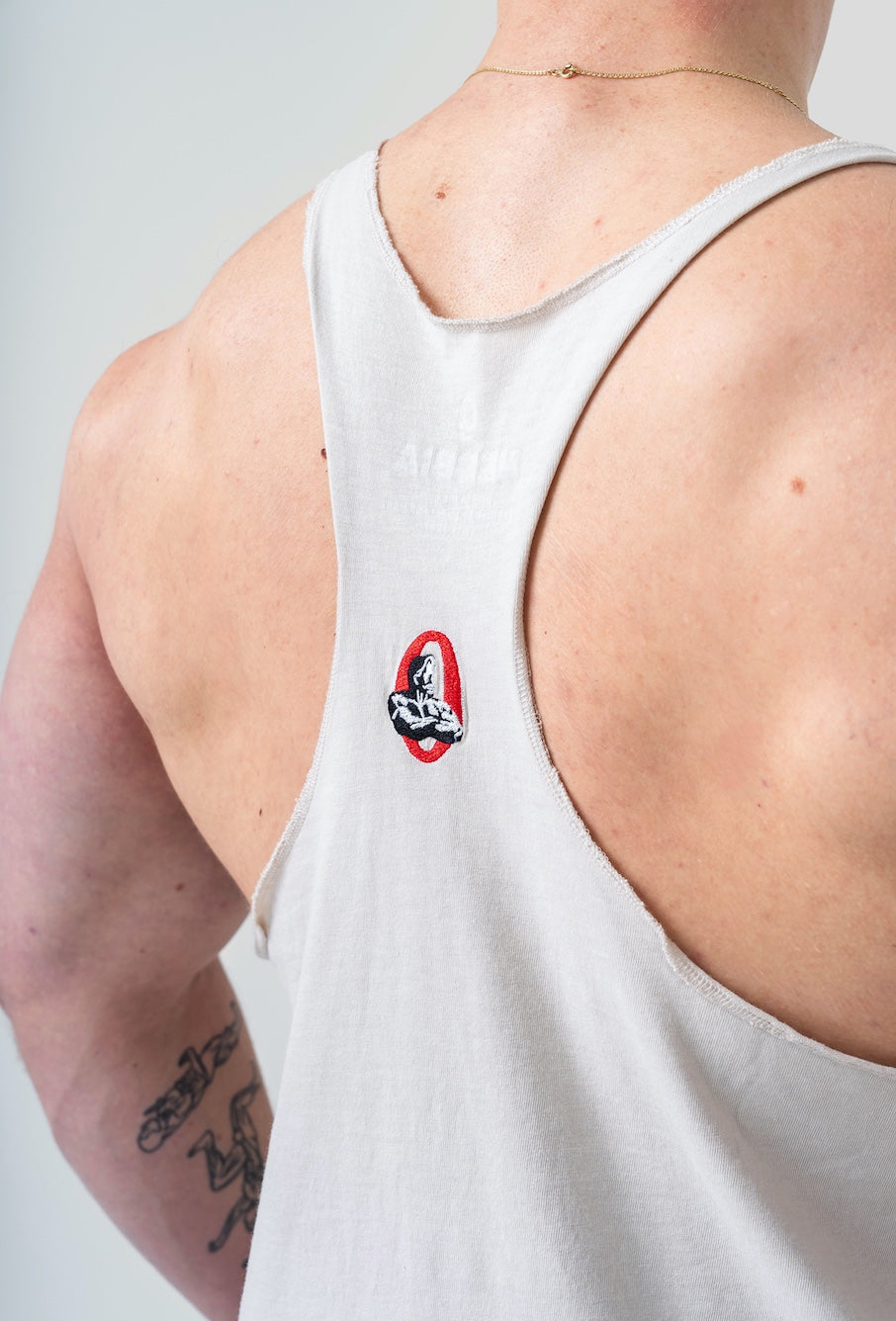 Side profile of the 791 light grey stringer showing the deep-cut armholes and thin straps for lat exposure.